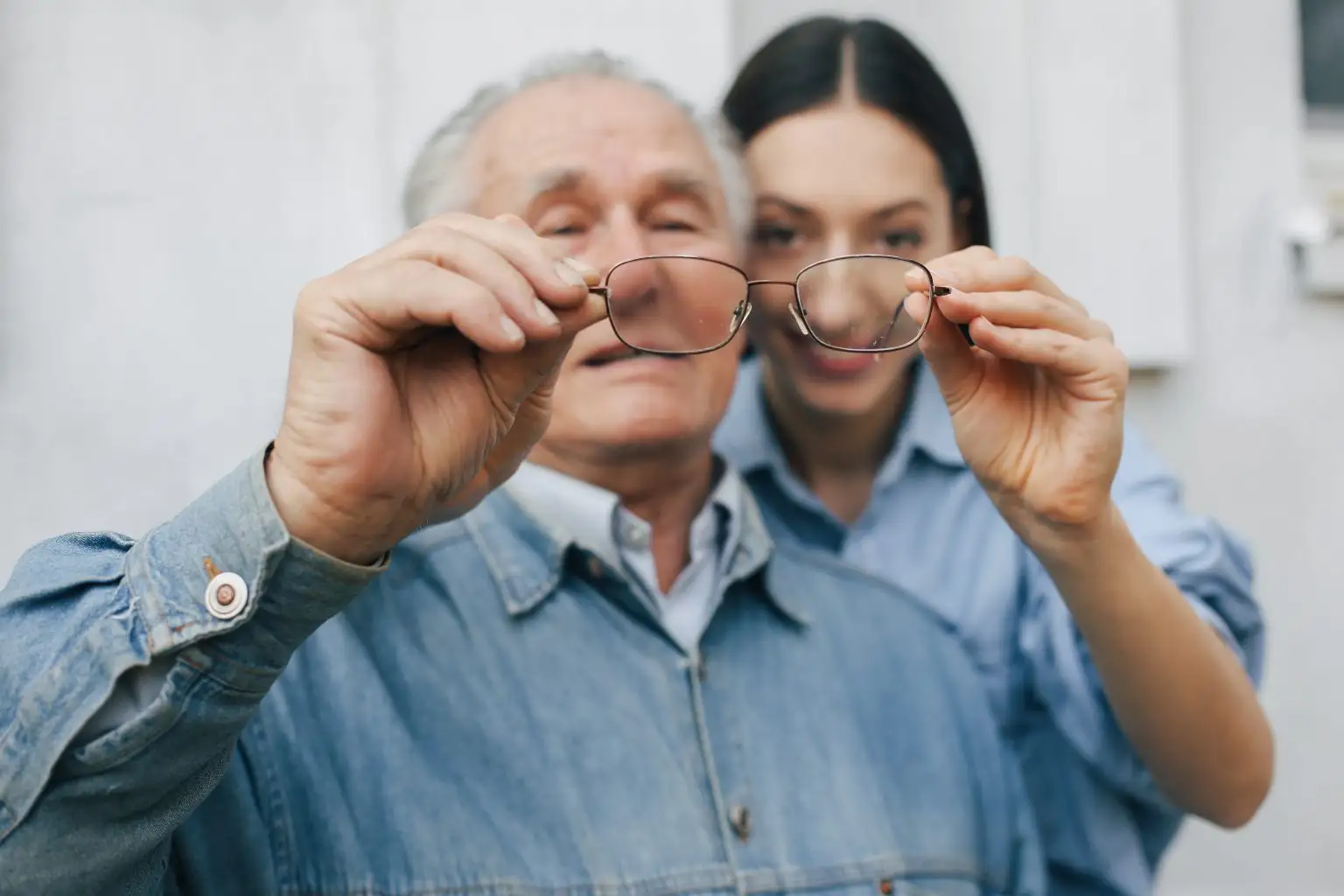 old-man-standing-gray-backround-with-his-granddaughter